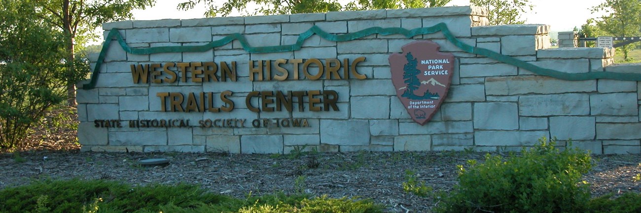 A stone-walled sign at the entrance of the western historic trails center.