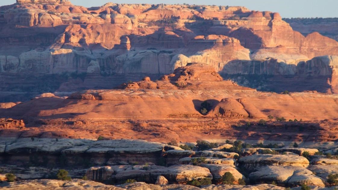 Multicolored geologic layers are highlighted at sunset
