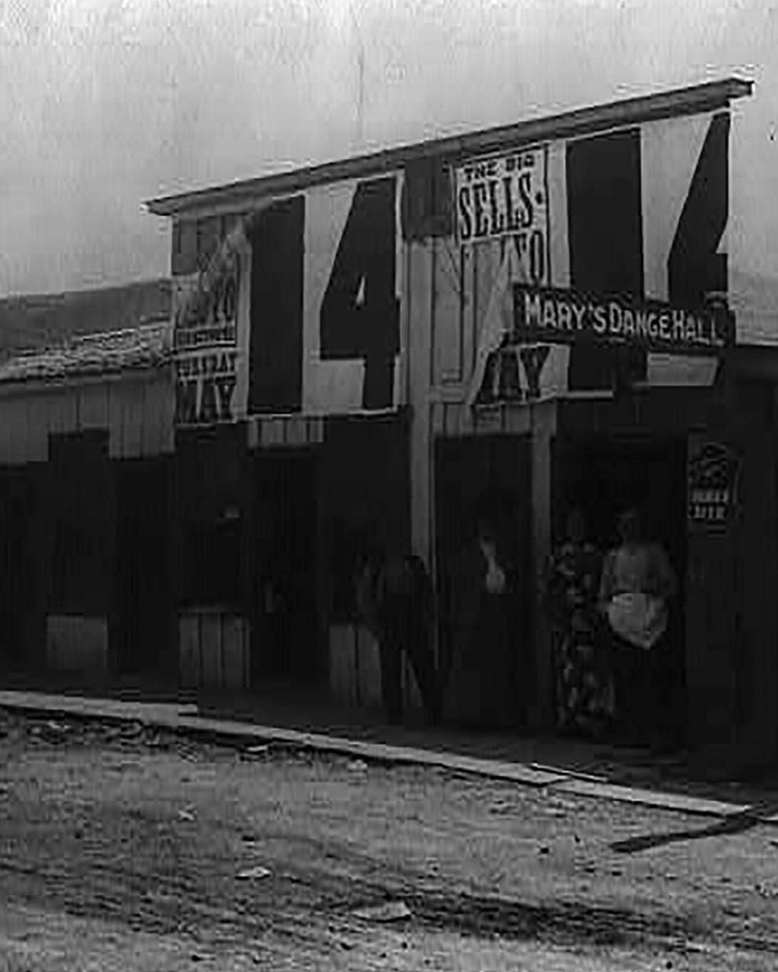Photograph shows two men and two women standing in front of Mary's Dance Hall.