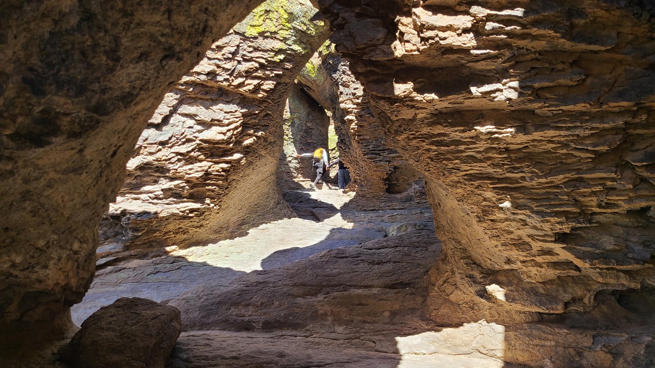 2 hikers hike up a tunnel formation