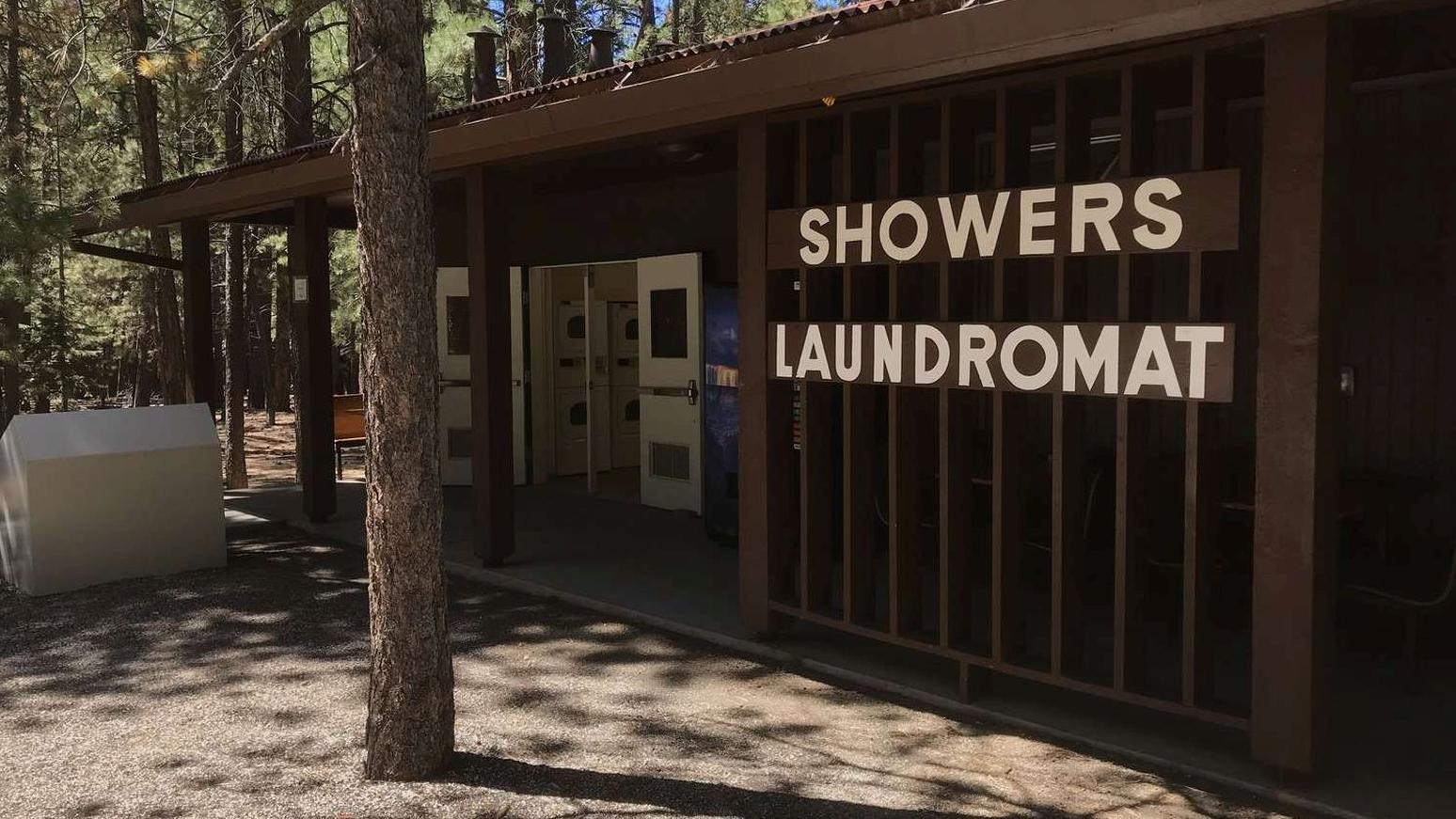 A single story brown wooden building with large white letters reads: 