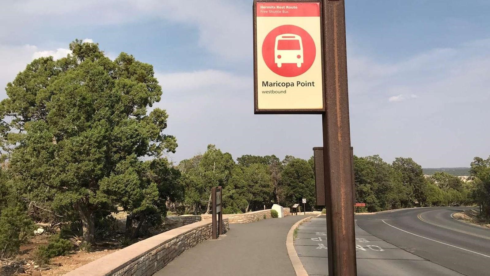 A red and white sign marks the waiting area for the park\'s shuttle service