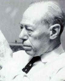 Man in suit looks through magnifying glass