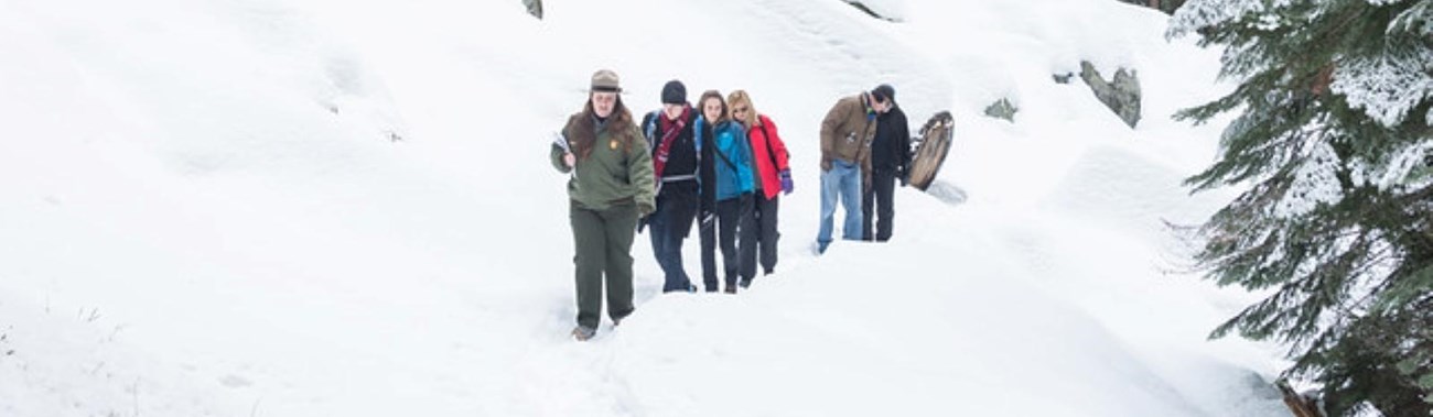 A ranger leads a tour through the snow