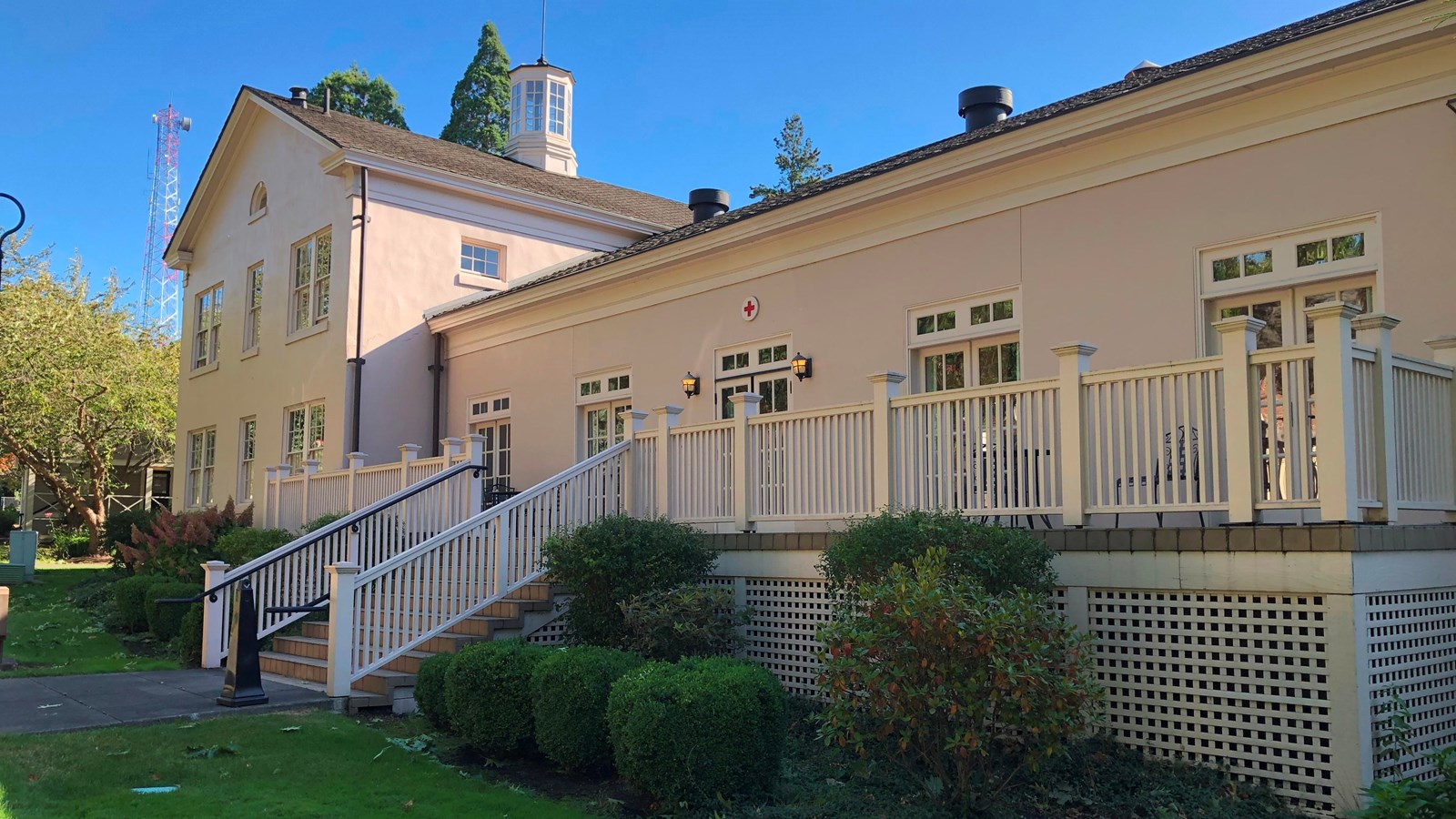 A light beige building with a small Red Cross insignia over one entrance.