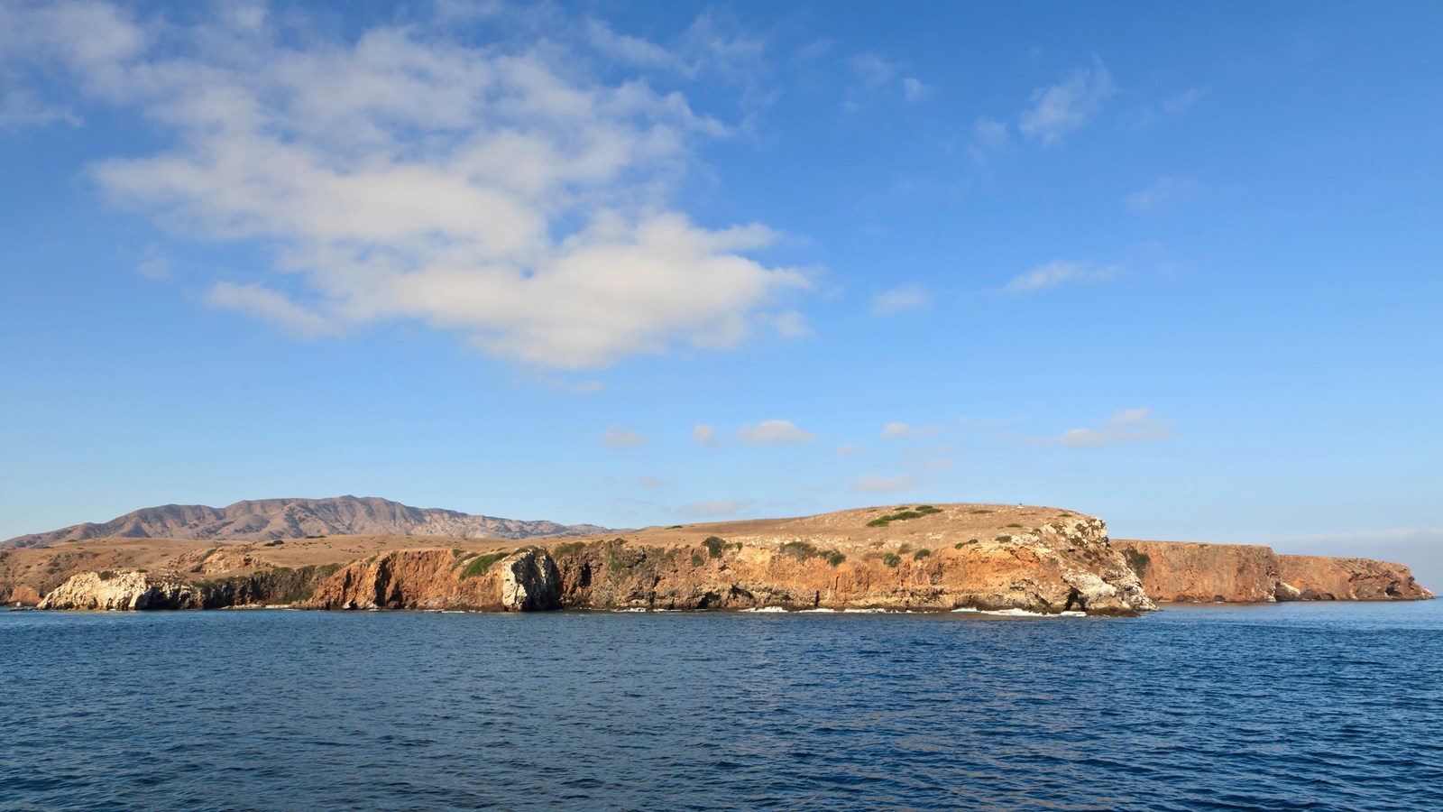 Rocky shoreline leading to a grassy terrace on the far eastern end of the island. 