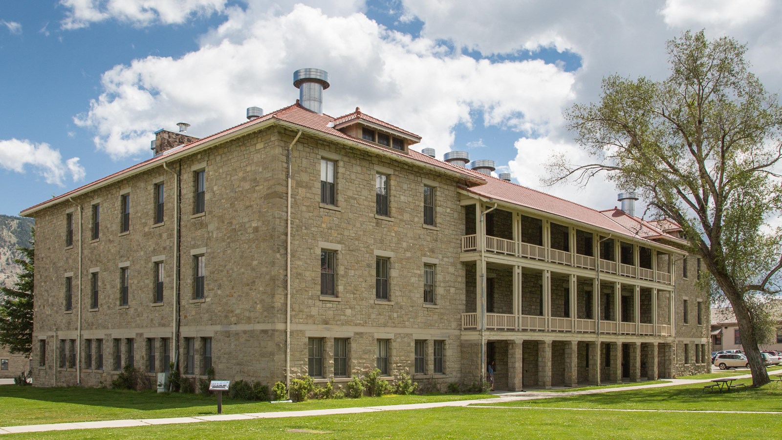 A historic building made of stone with a roof with red shingles.