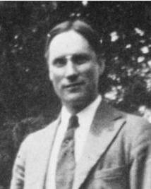 Man in suit and glasses poses for picture. 