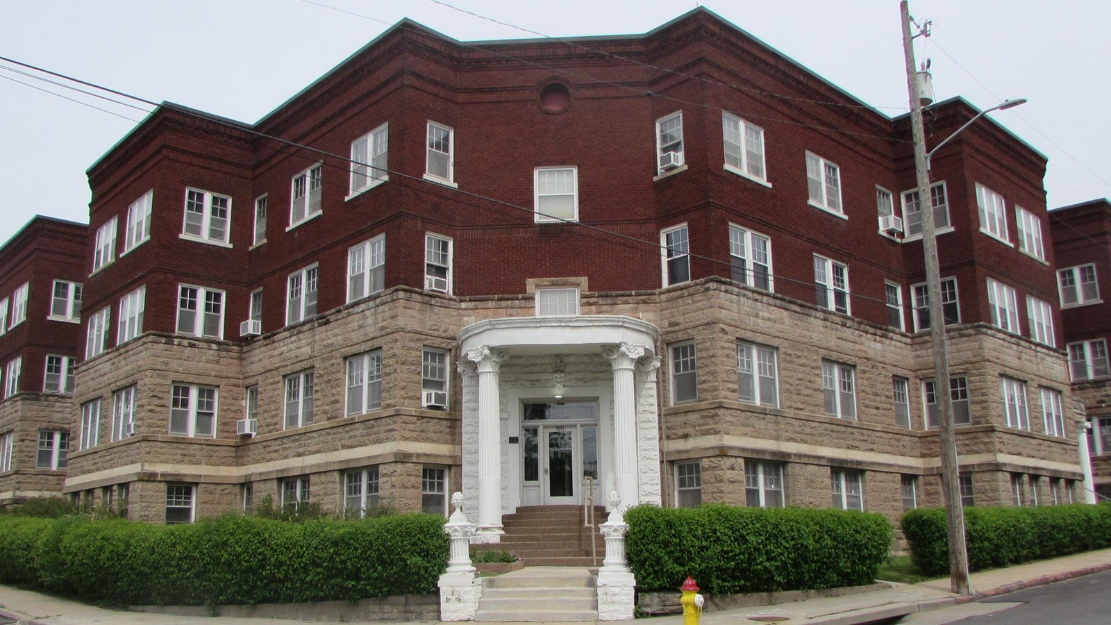 Italian Renaissance Revival apartment building on corner. Lower levels of stone, upper two of brick