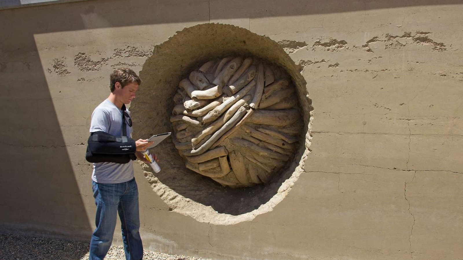 A visitor stands in front of Earth Wall