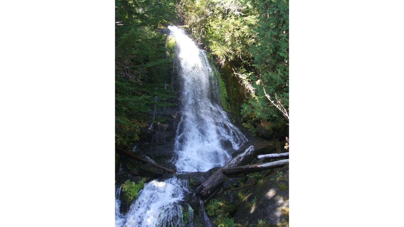 Small waterfall with series of cascades over mossy bedrock