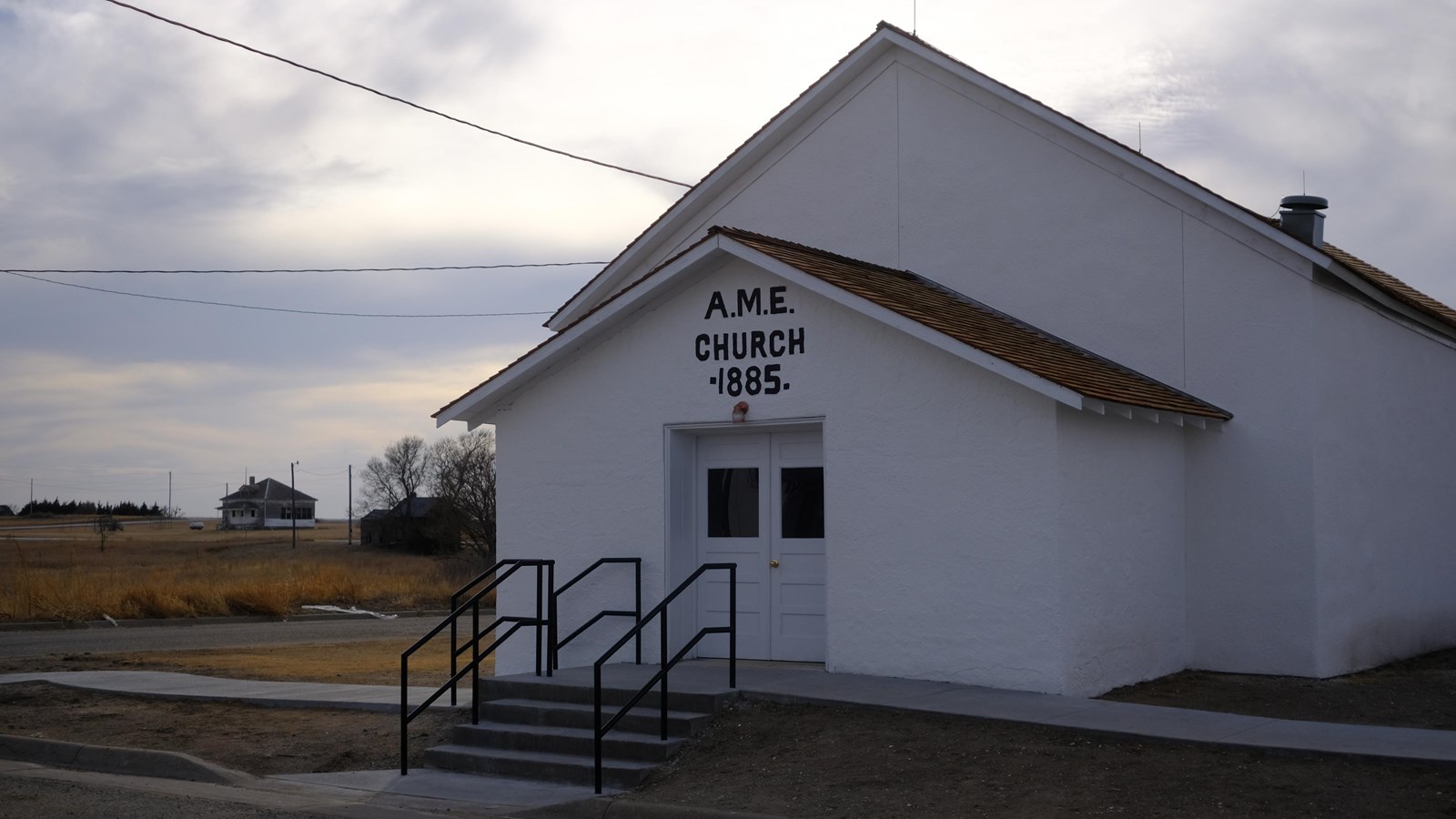 A white stucco church with A.M.E. Church 1885 written above the front door