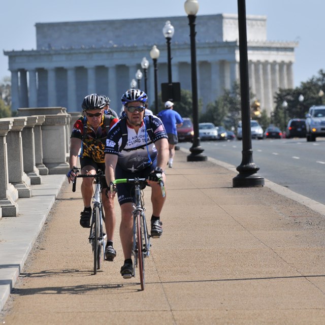 Cyclists cross Arlington Memorial Bridge.