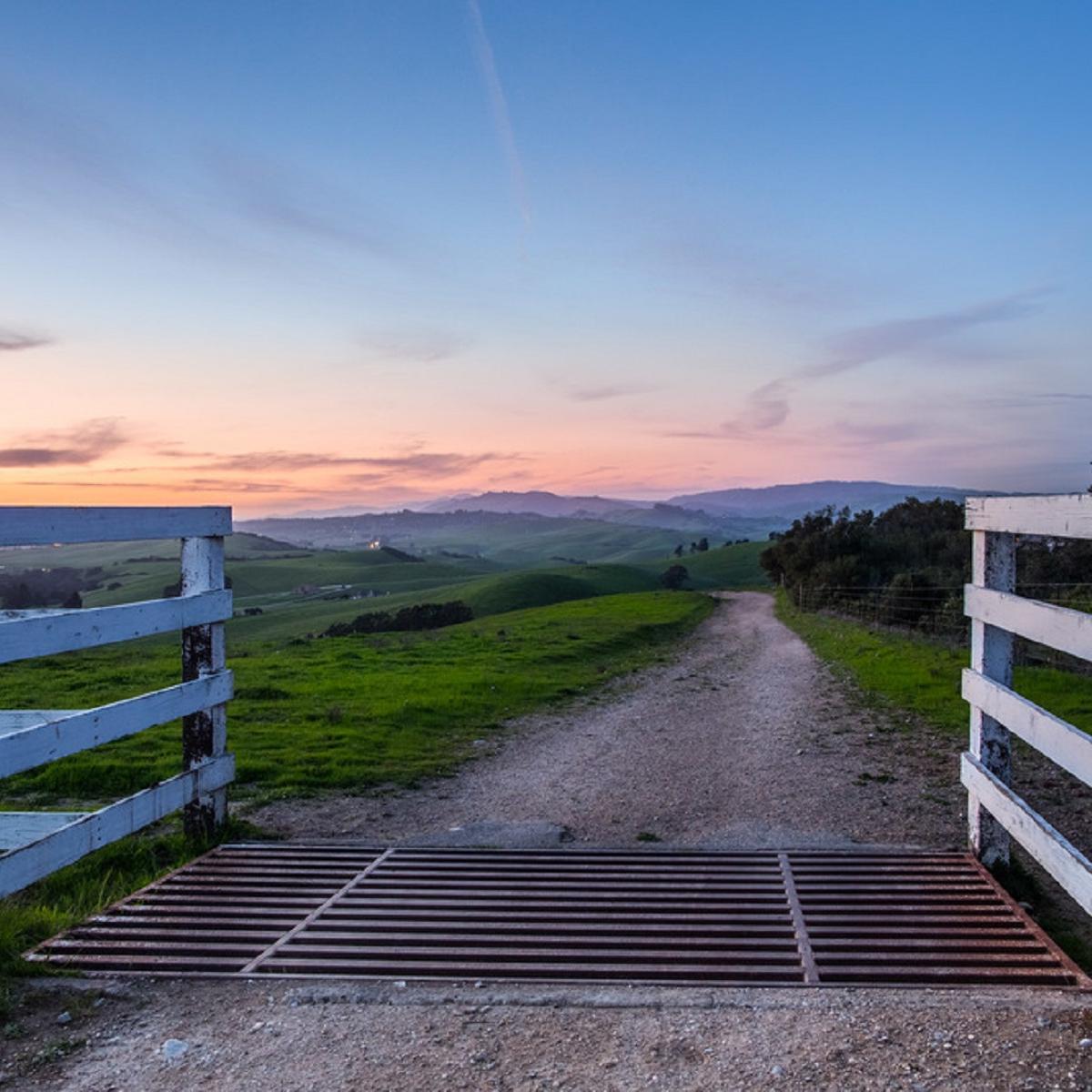 Fence with landscape and sunset in background 