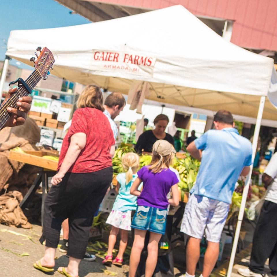 Man playing guitar at open market. 