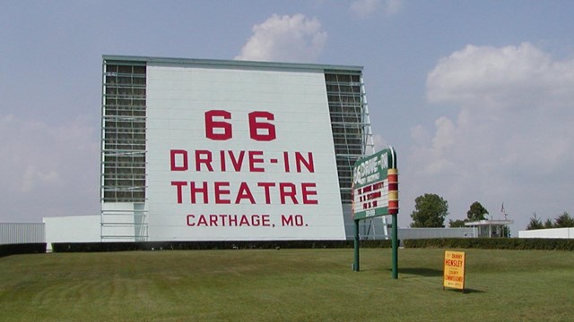A large Route 66 drive in screen on top of a grassy hill.