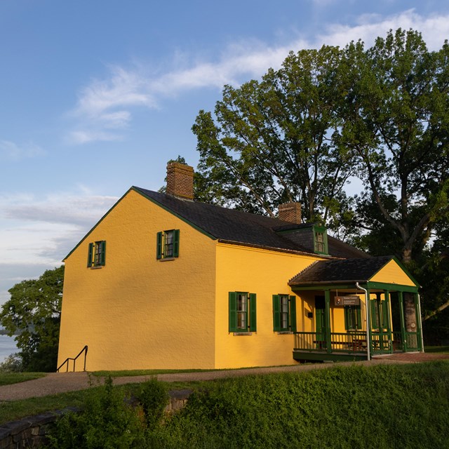 A yellow house overlooking the Potomac River from above.