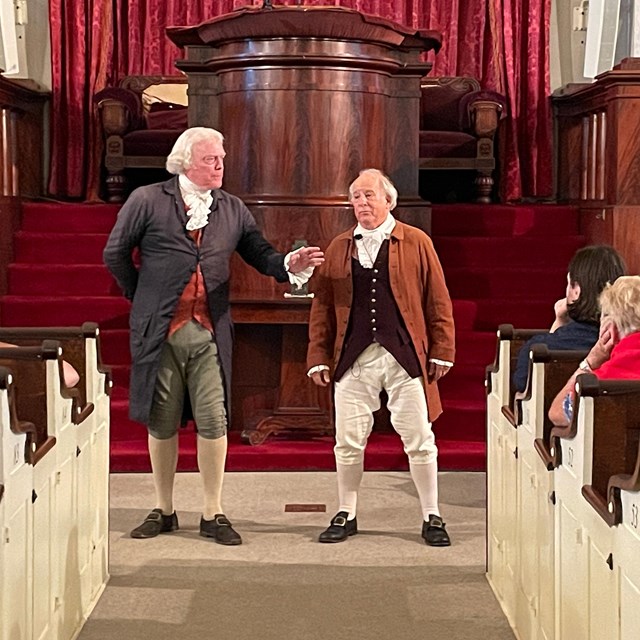 Actors portraying Benjamin Franklin and John Adams in the United First Parish Church