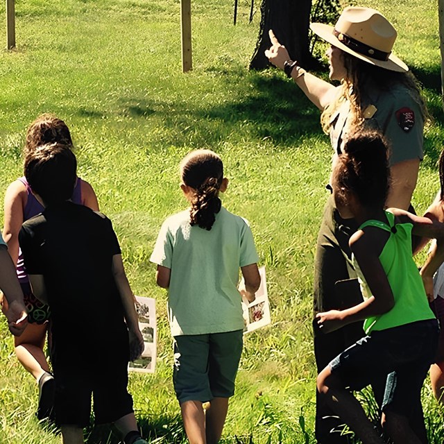 Ranger with a group of children at Peace field