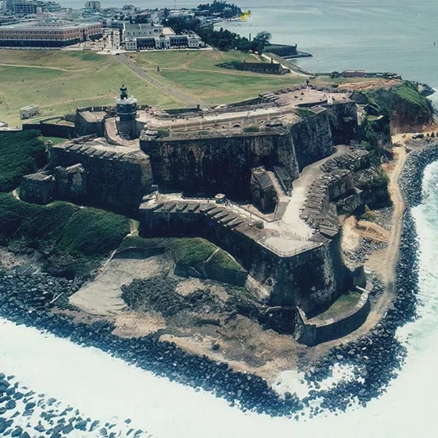 Photograph from above of the fort built into a cliff side above water