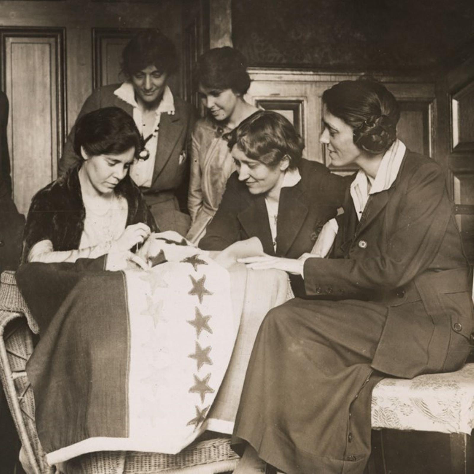 Women sewing stars onto a flag