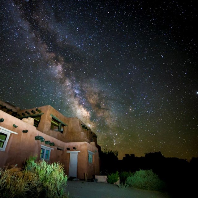 the milky way in the sky above an adobe style house