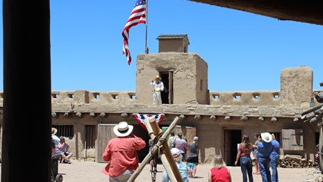 Interpreter at reconstructed Fort presenting ranger program for visitors