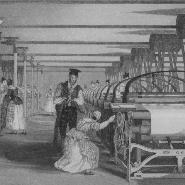 A woman weaving at a powerloom while a man supervises her