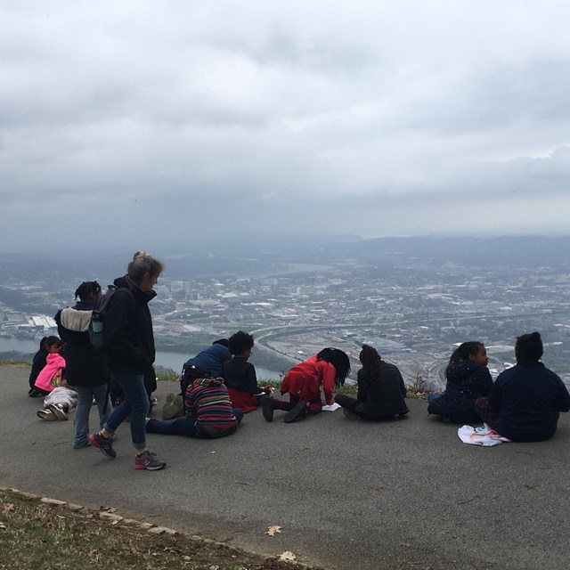 Students overlooking a city from a sidewalk