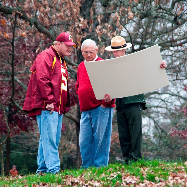 A ranger shows visitors a map