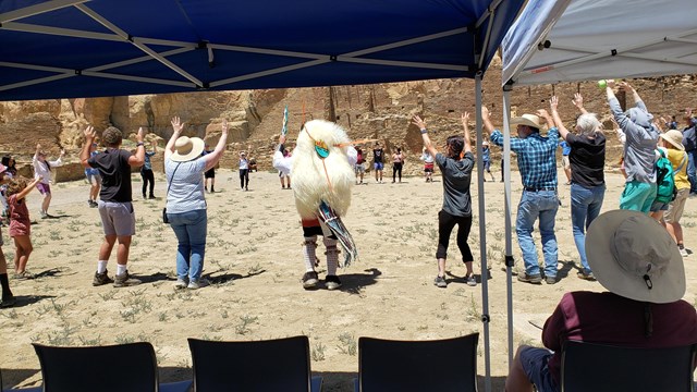Visitors dancing in a circle alongside the Pueblo Enchantment Dancers.