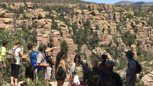 A park ranger points out rock formations to a group of visitors