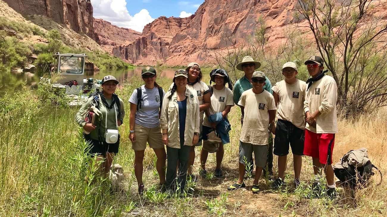 a group of people posing in front of a desert canyon
