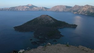 Wizard Island in Crater Lake with moon rising in the distance