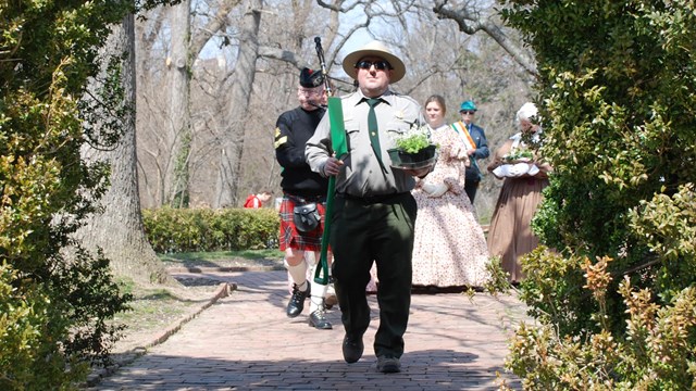 Ranger carrying shamrocks in a process of people that includes an Irish flag-bearer