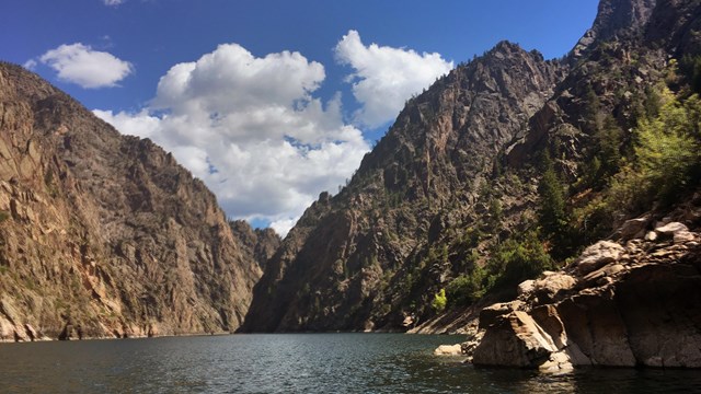 A reservoir between tall canyon walls with steep cliffs