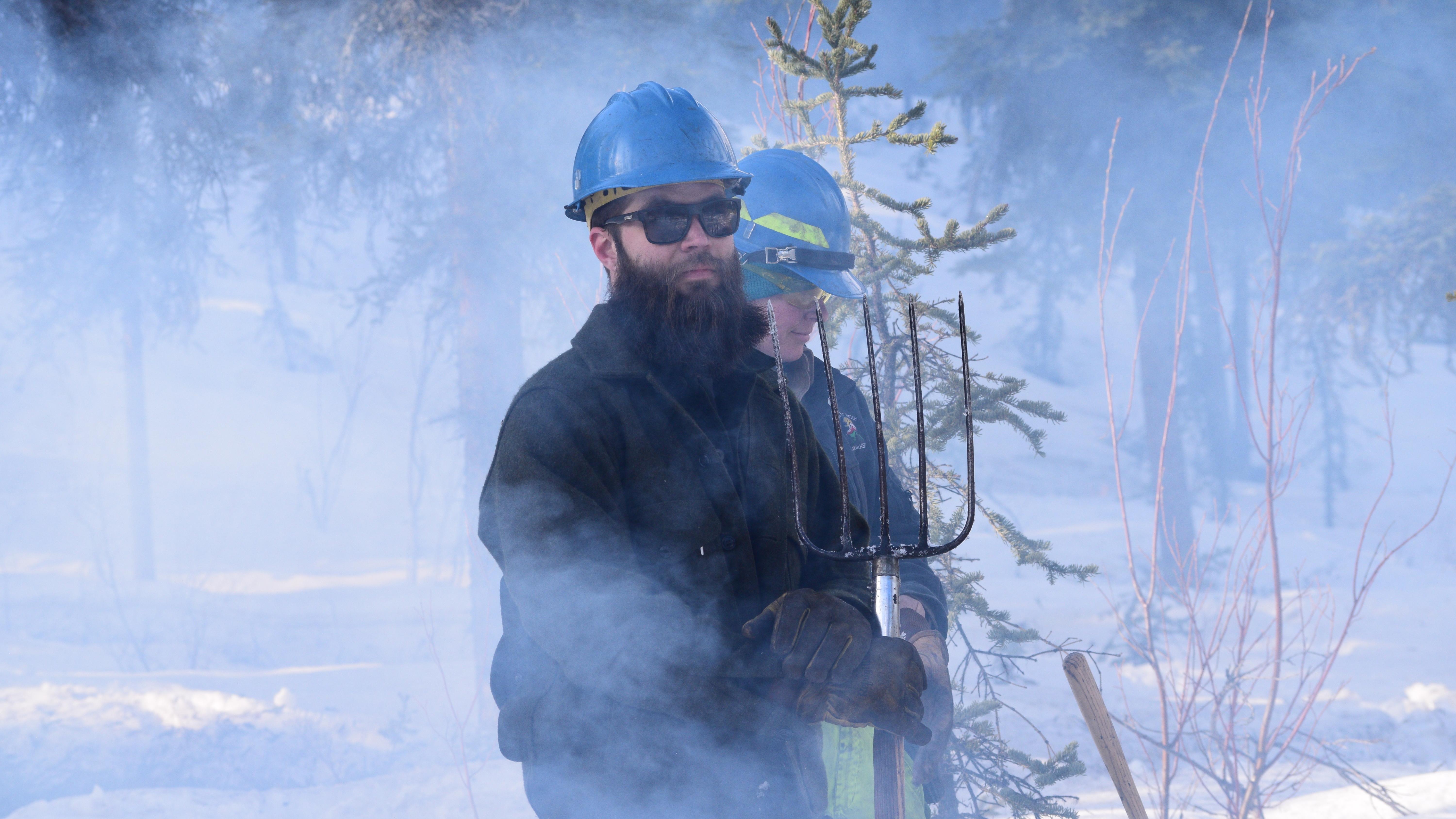 A firefighter stands in a smoky scene