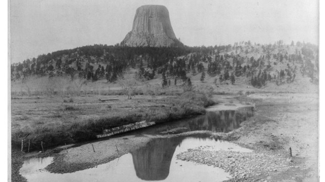 Historic photo of Devils Tower with river in foreground