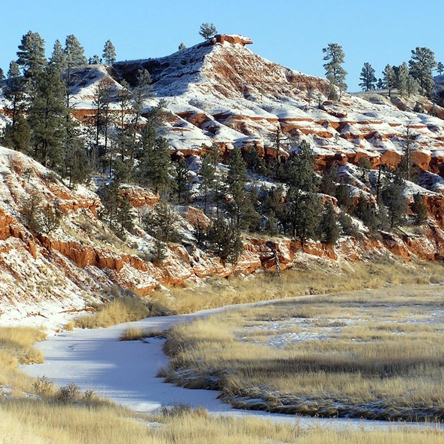 A river in winter with snow-covered bluffs behind