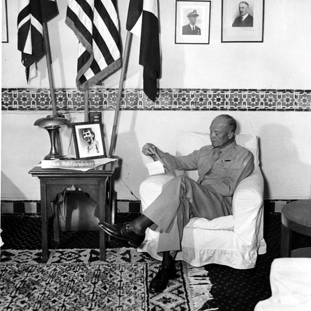 A black and white image of General Eisenhower writing a letter