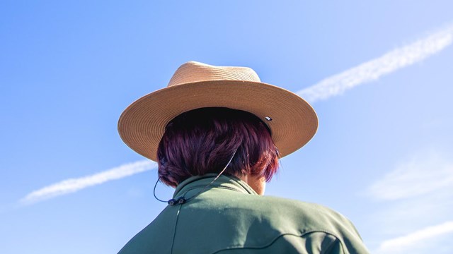 The back of a ranger's flat hat against a blue sky.