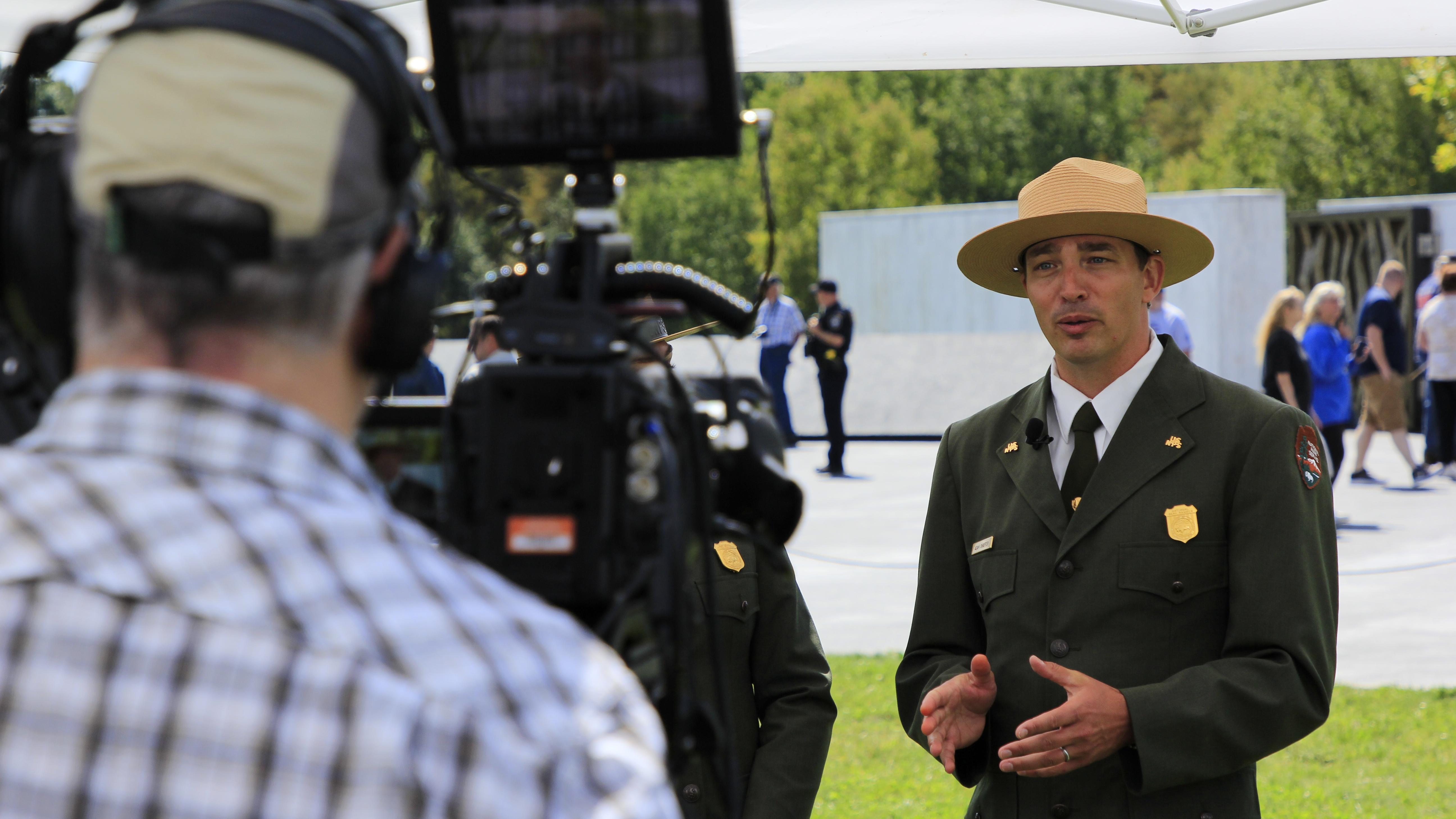 A ranger talking while a cameraman films him