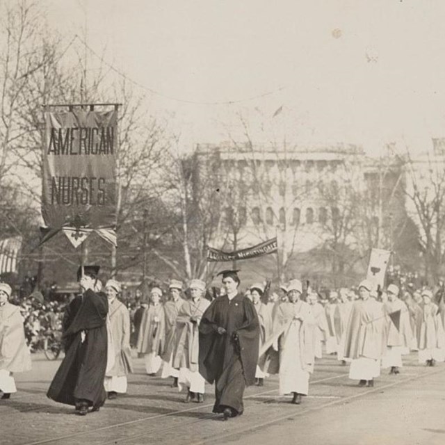 A black white photograph of nurses at a suffrage parade in front of the U.S. Capital