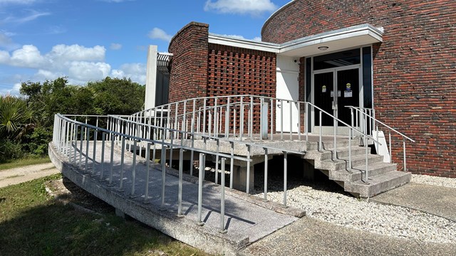 A wheelchair ramp on the side of a brick building. 