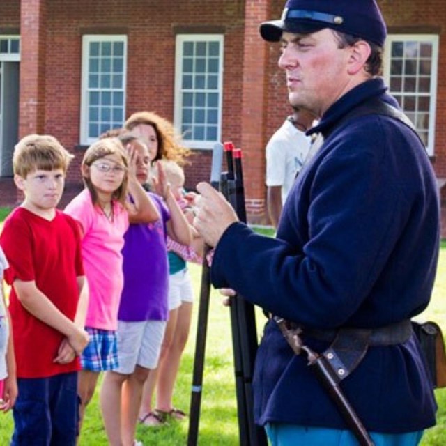 kid with civil war uniform standing with other kids, adult man in civil war uniform