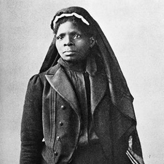 Black women in head cover, standing