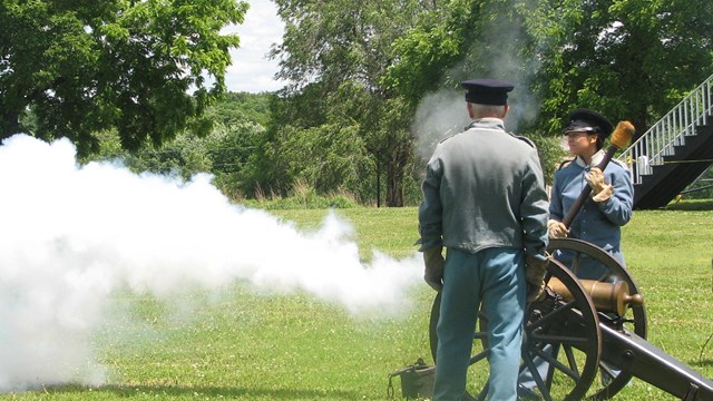 Crew of soldiers fire a cannon