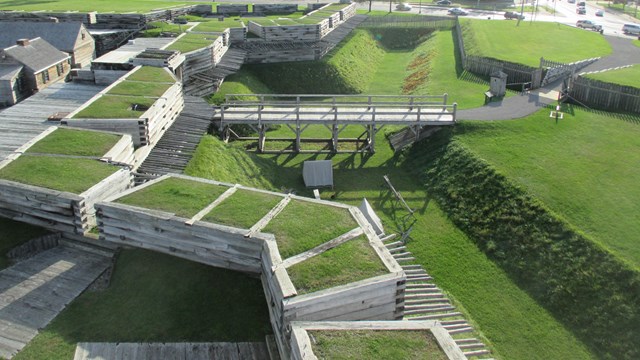A view of the fort wall as seen from above. It is covered in grass. 