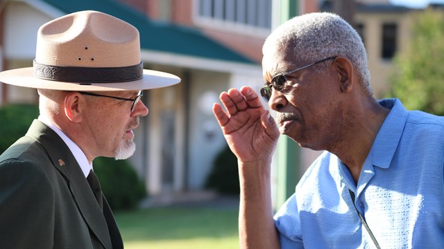 A Freedom Rider salutes a man in a National Park Service uniform.