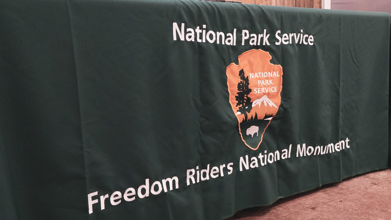 A tablecloth with an arrowhead and Freedom Riders National Monument sewn into the fabric.